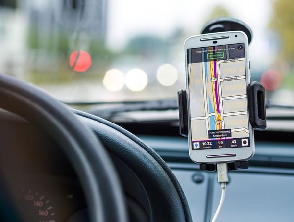 GPS tracking software shown on a mobile phone in a car