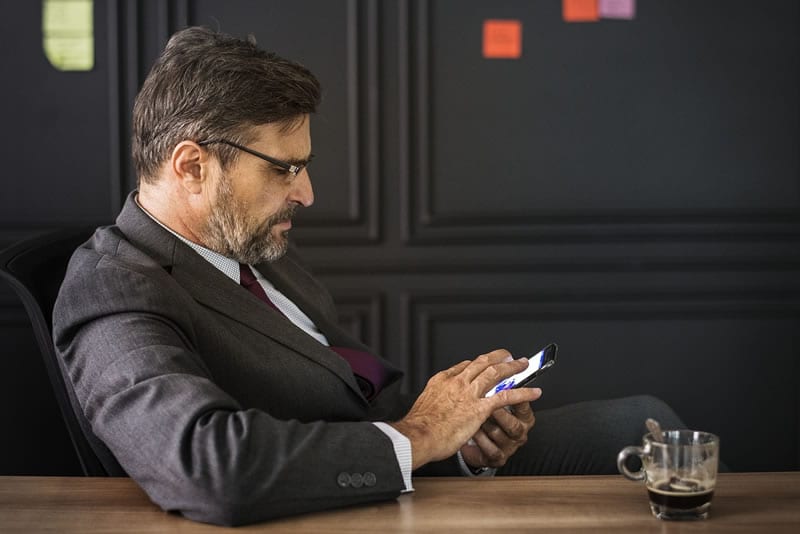 Man texting a message. Carpet cleaning software and window cleaning software includes automated text messaging features.