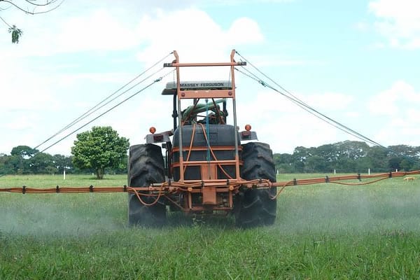 Tractor spraying chemicals to kill pests in field